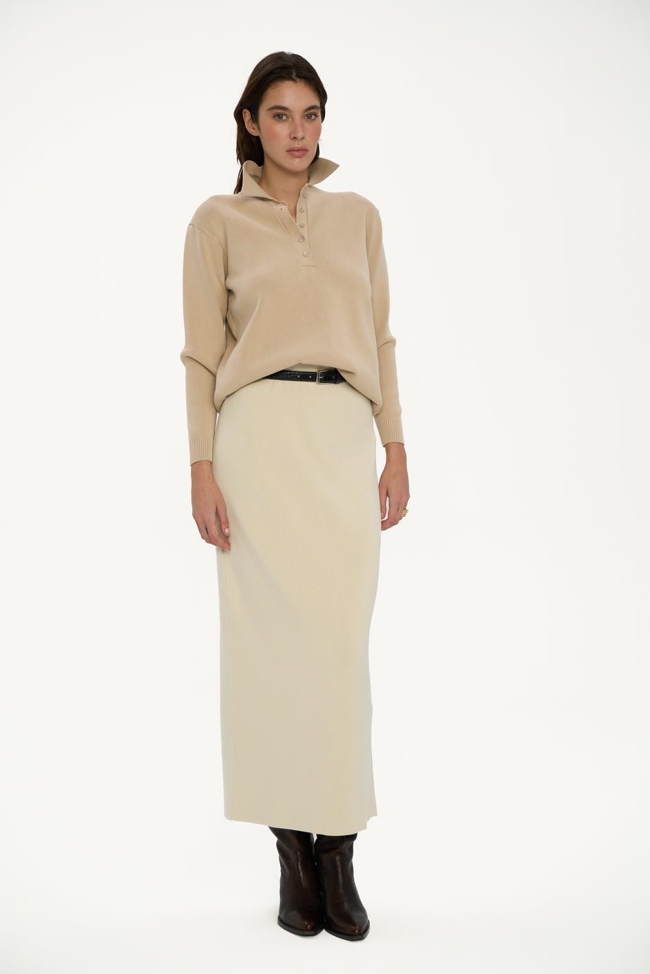 Woman wearing a beige blouse and cream skirt on a white background