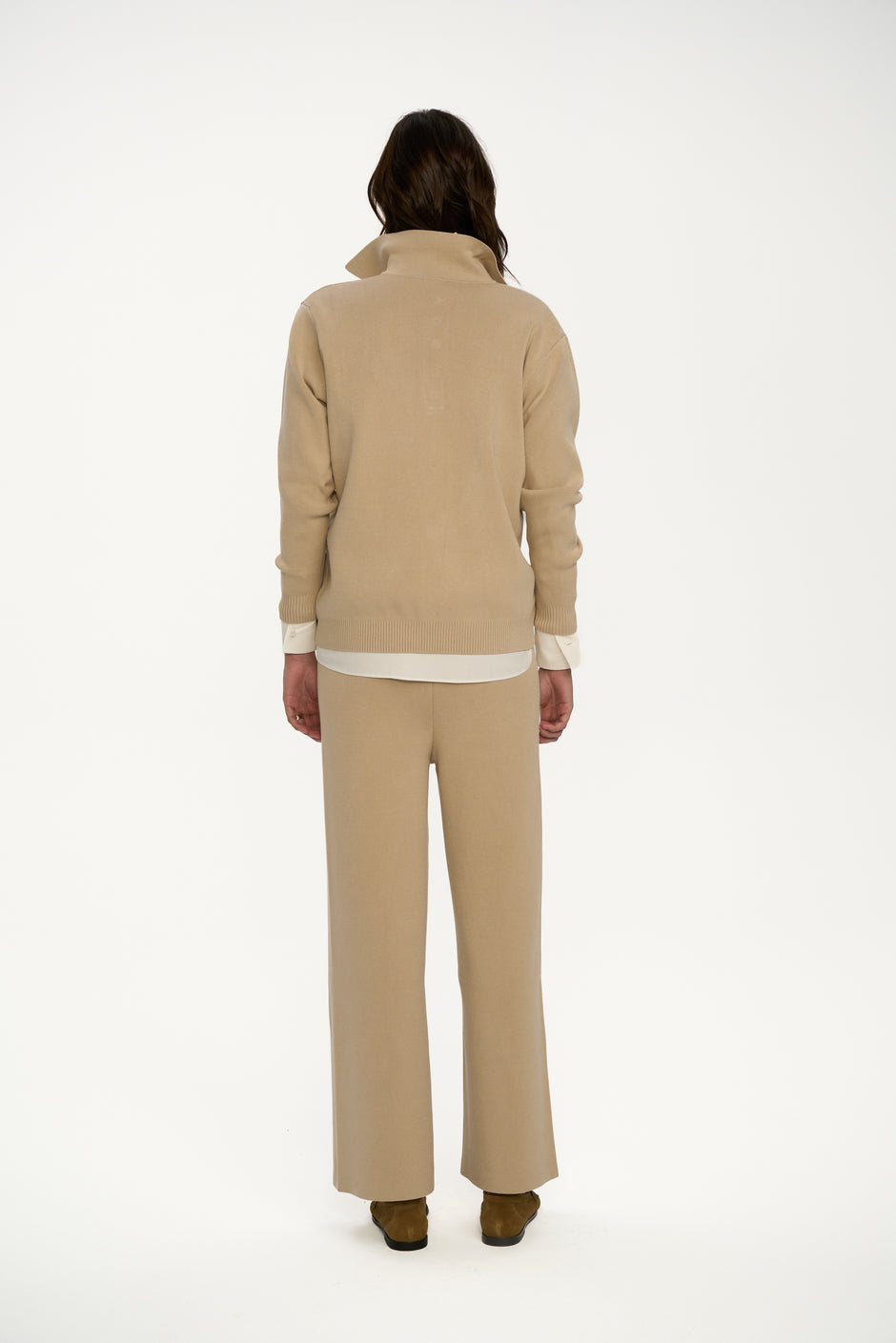 Person wearing a beige suit on a white background