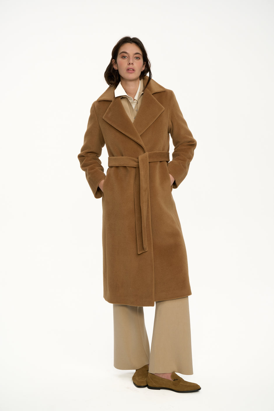 Woman wearing a long brown wool coat on a white background