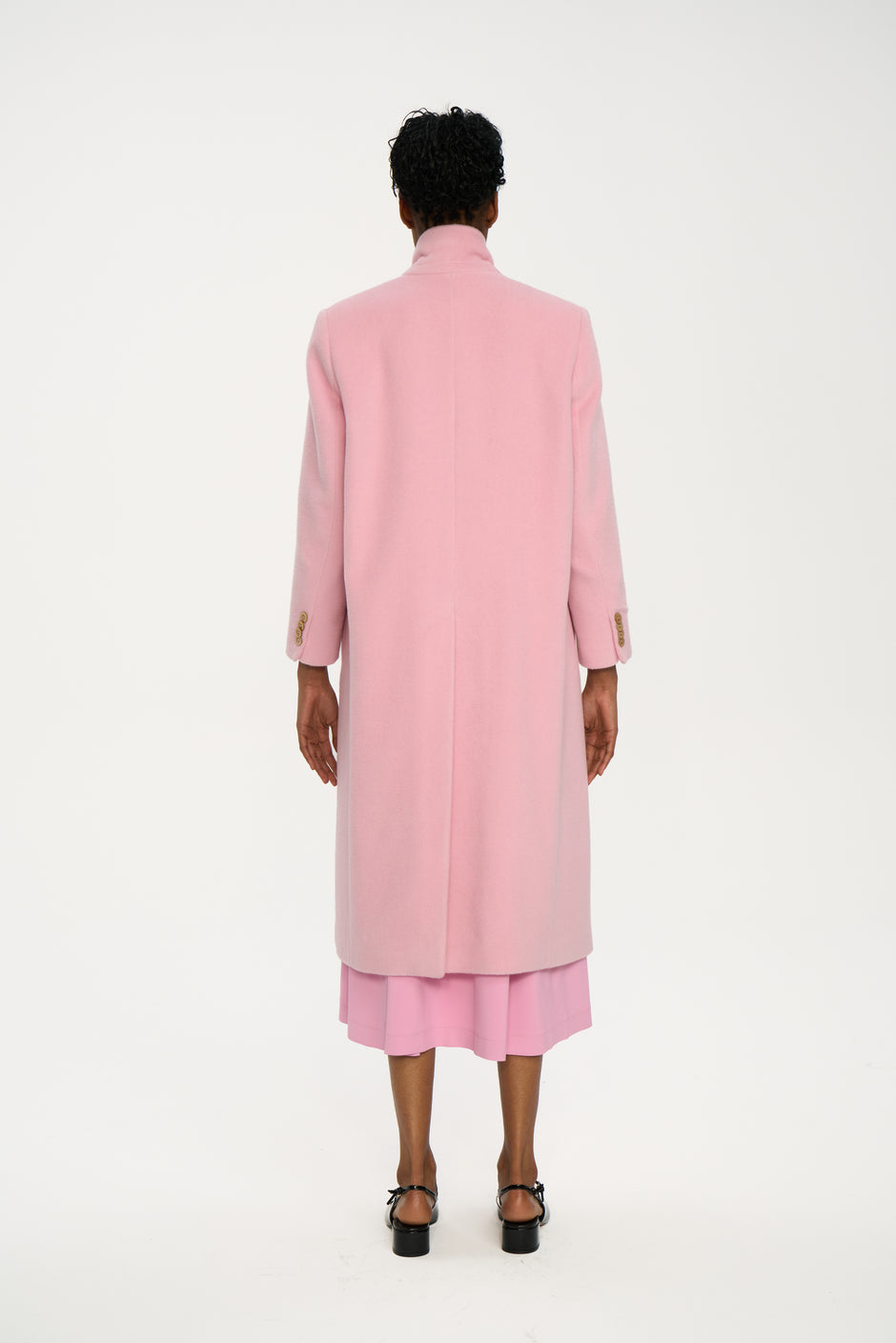 Powder pink single-breasted wool coat with high collar styled over matching pink dress, full length back view on model – Inner Tiger