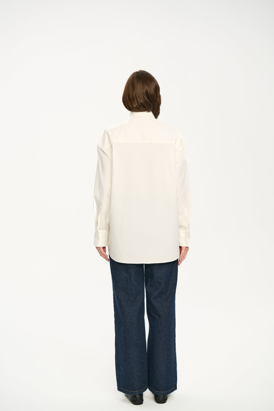 Person wearing a white shirt and blue jeans on a white background