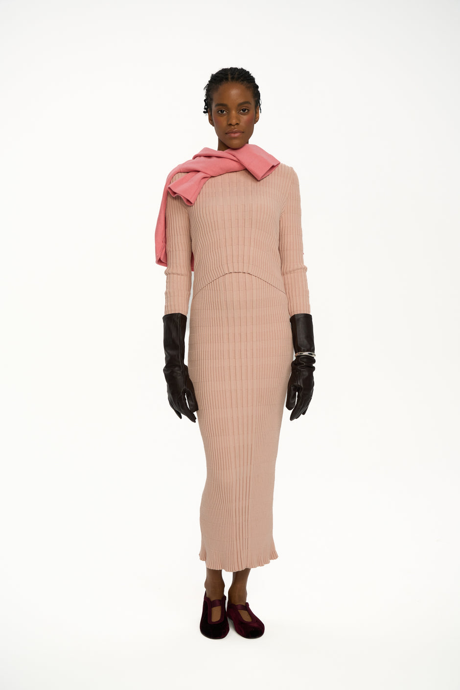 Blush ribbed knit midi dress with high neck styled with pink sweater over shoulders, black gloves and velvet heels on model, breastfeeding-friendly double-layer design – Inner Tiger