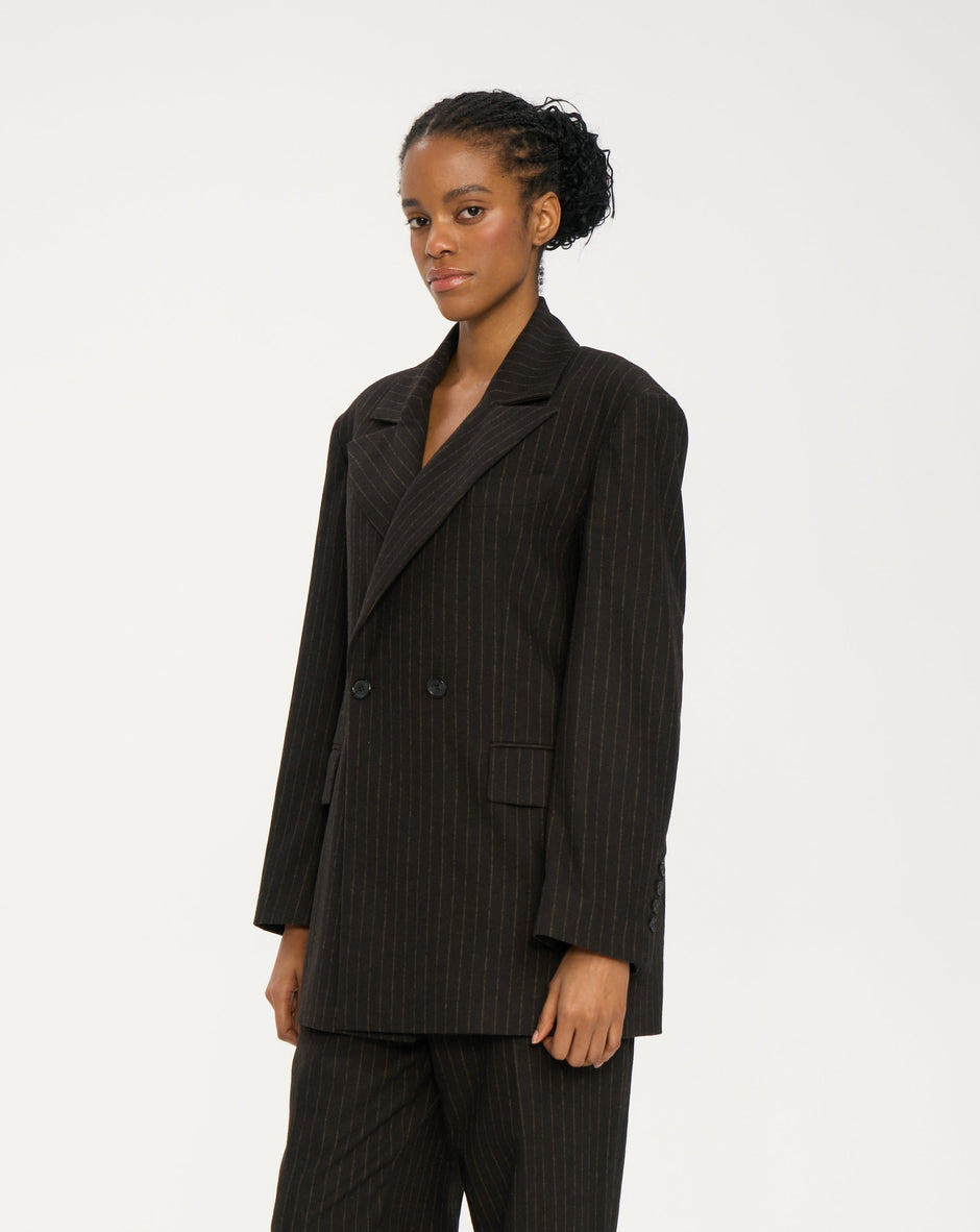 Woman wearing a black pinstripe suit on a white background Inner Tiger