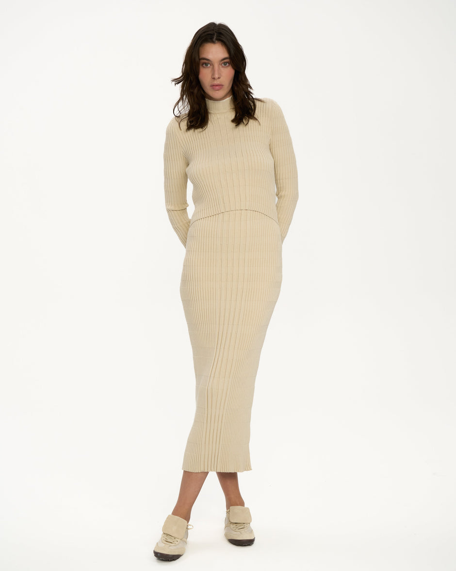 Cream ribbed knit midi dress with high neck and long sleeves on model in sneakers, relaxed full length front view, breastfeeding-friendly double-layer design – Inner Tiger
