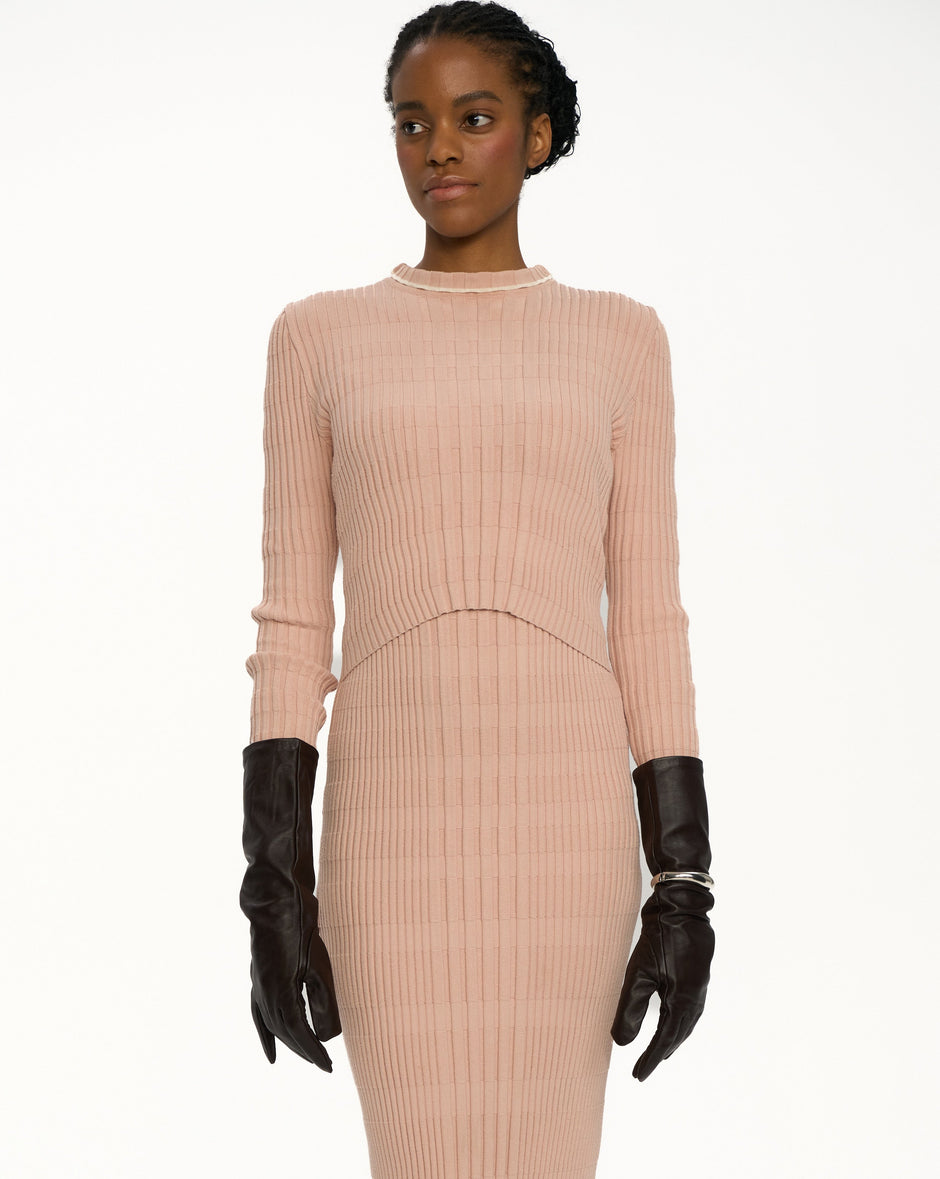 Blush ribbed knit dress with high neck and long sleeves on model wearing black leather gloves, breastfeeding-friendly double-layer top detail – Inner Tiger