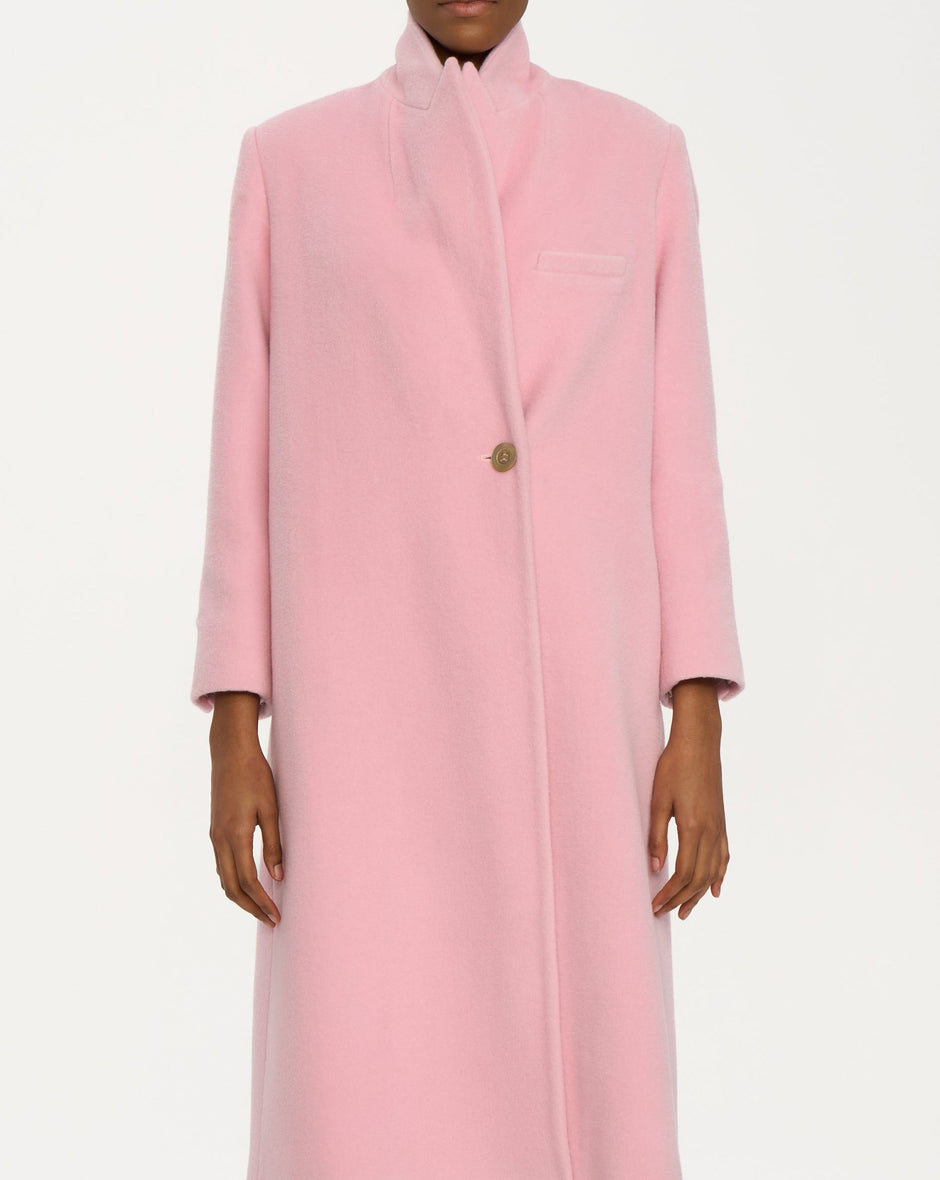 Pink coat worn by a model on a white background
