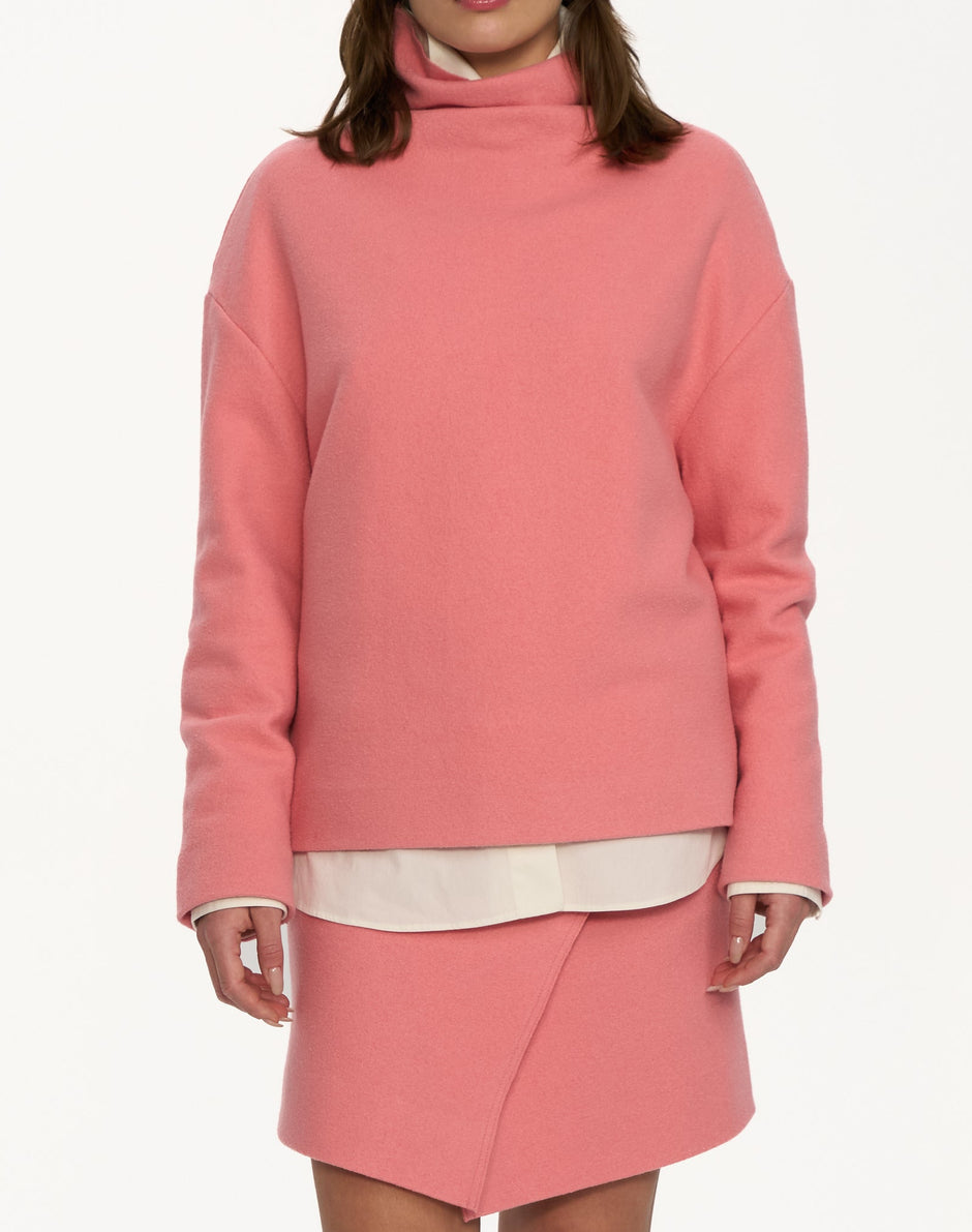 Close-up of powder pink high-neck wool sweater showing smooth fabric and relaxed straight fit – Inner Tiger
