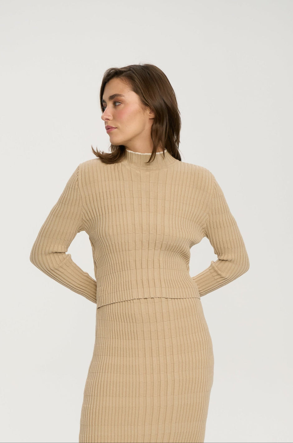 Soft beige ribbed breastfeeding knit dress with high neck and fitted bodice on model, upper body view – Inner Tiger